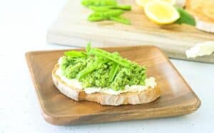 Pea and Fava Bean Crostini on a wooden plate