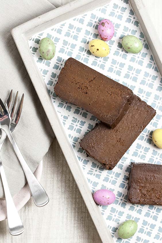 a patterned tray with pieces of chocolate cake and speckled Easter eggs