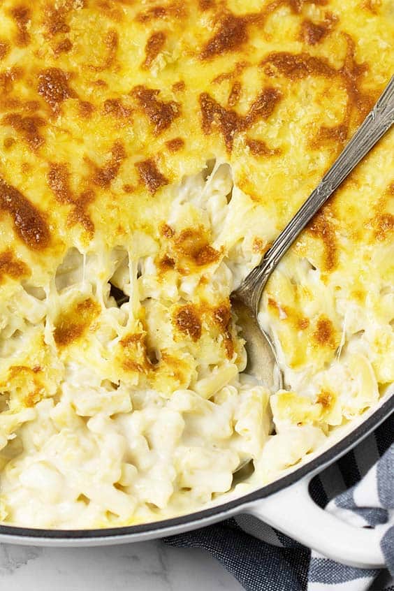 close up shot of baked macaroni cheese with a serving spoon