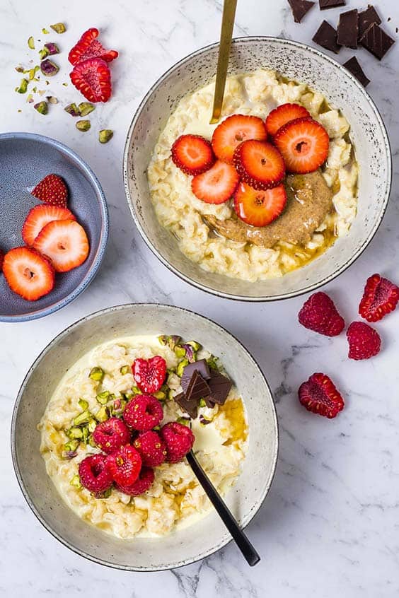 steam oven oatmeal bowls with fresh raspberries, strawberries, honey, nuts and chocolate
