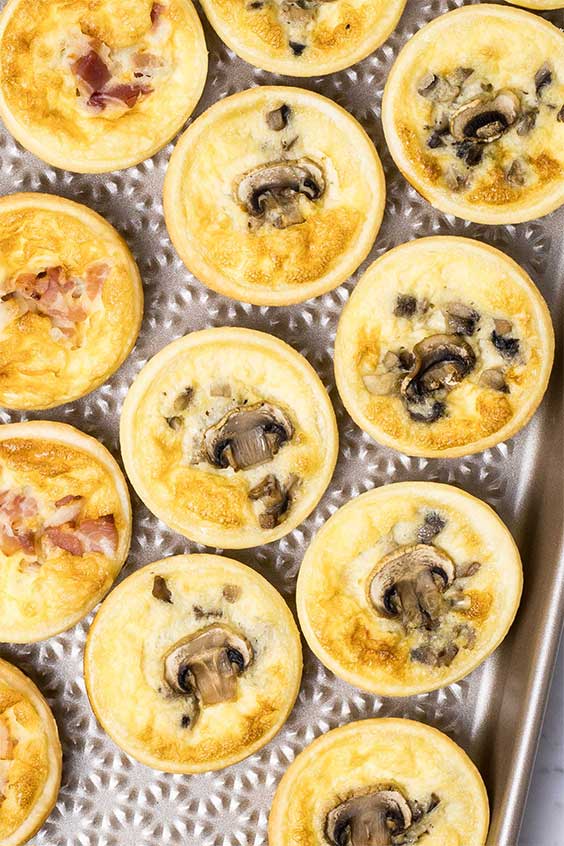 A rose gold baking tray with mushroom and bacon mini quiche on it