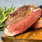 a sous vide cooked steak, cooked medium rare and sliced in half so the interior doneness is visible.