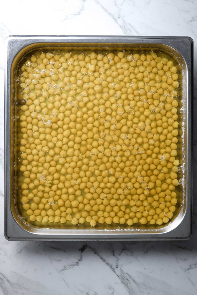 cooked chickpeas in a square baking tray