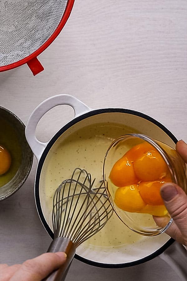 egg yolks being poured into custard
