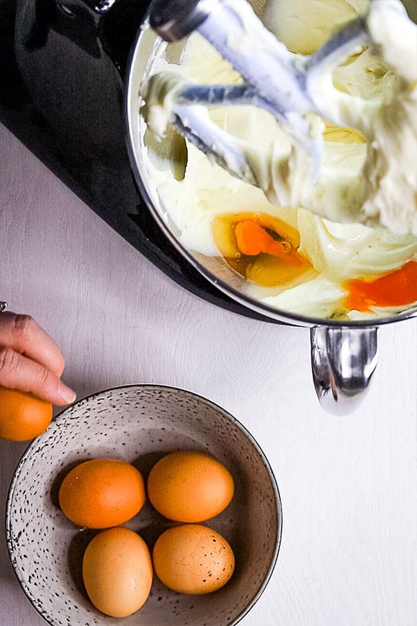 eggs being added to cheesecake batter