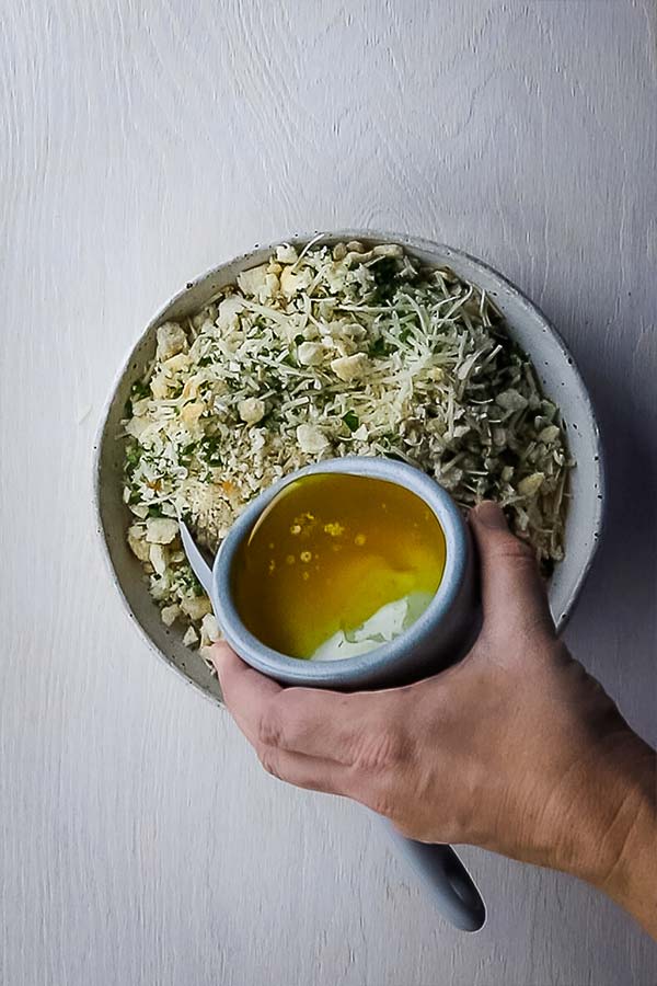 pouring butter into crumbs