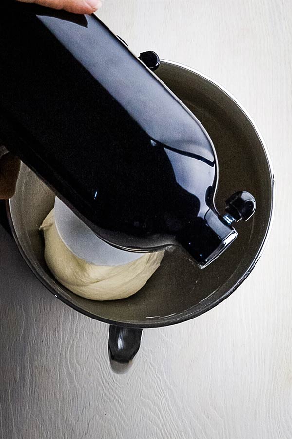 An overhead picture of the dough in the mixing bowl that has formed a ball