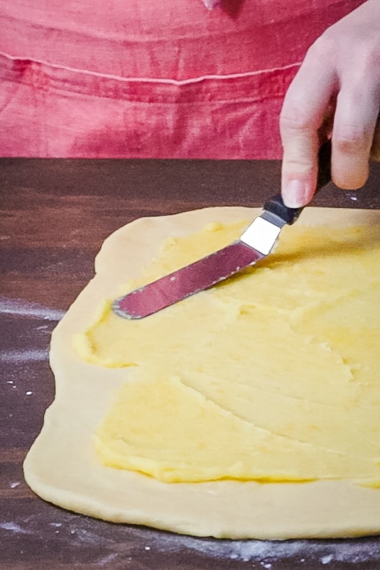 spreading filling onto lemon buns