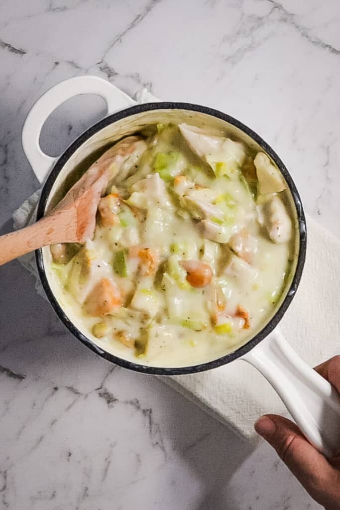 mixing meat and vegetables into pie gravy