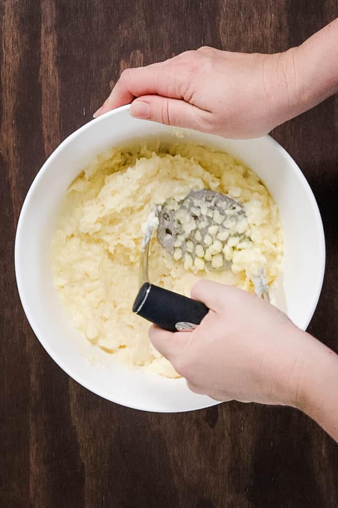 mashing potatoes in bowl