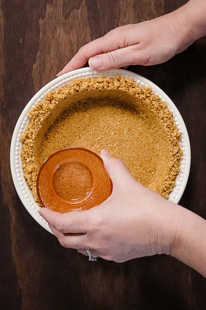 pressing pie crust into plate