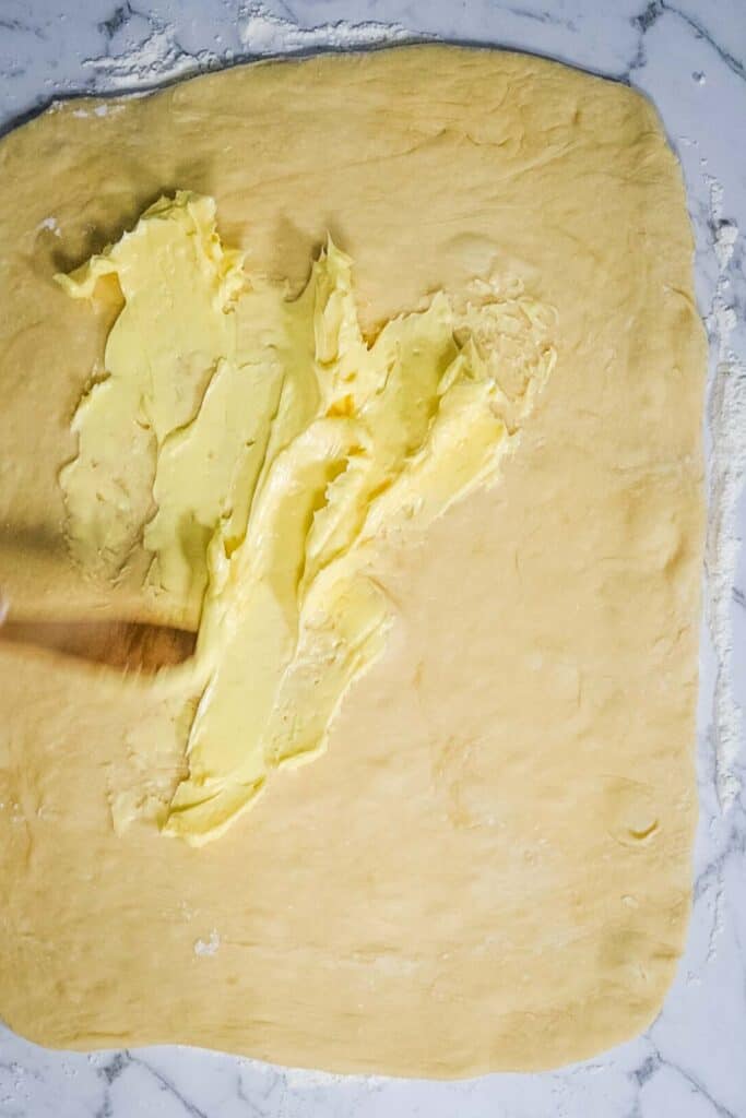 garlic butter being put on dough
