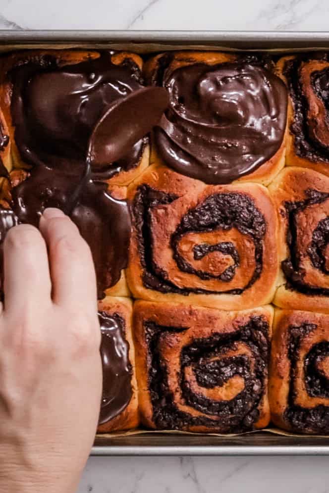 spreading glaze over chocolate brioche buns