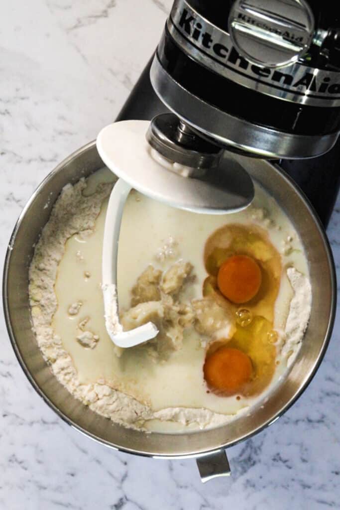 Two eggs adding into the mixer bowl