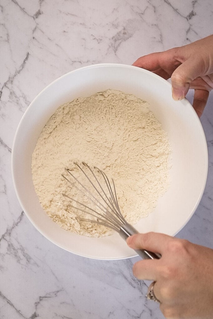 whisking dry ingredients in a white bowl