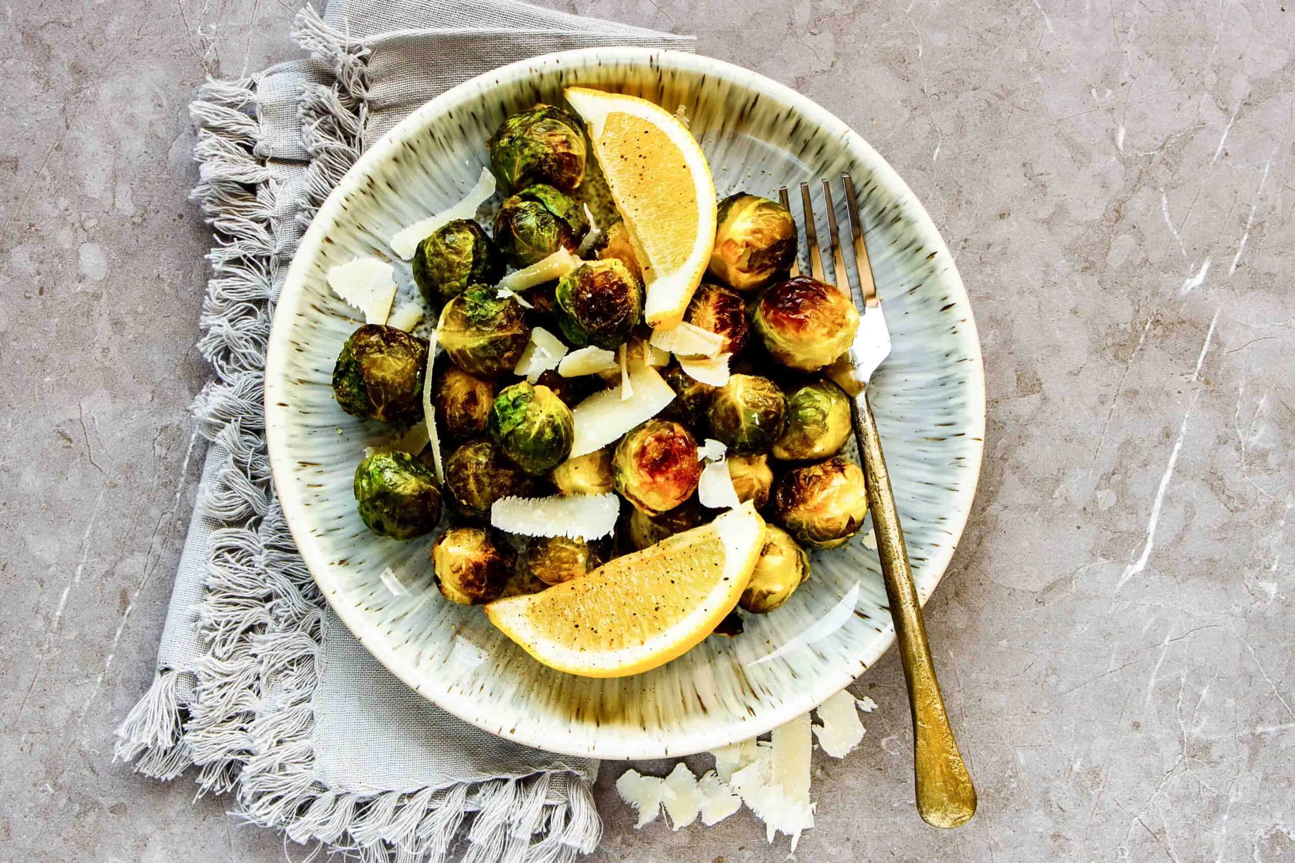 landscape view of fried brussels sprouts in plate with parmesan cheese