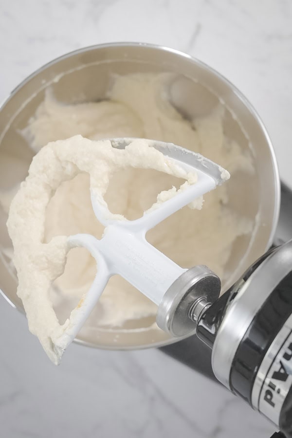 Creamed butter and sugar mixture on a stand mixer paddle.