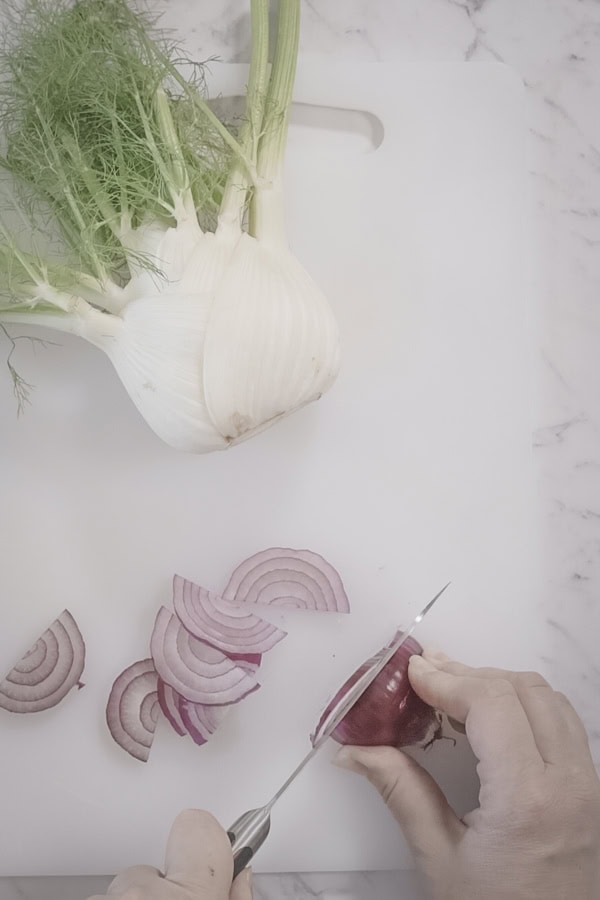 slicing fennel and onions for baked fish with fennel