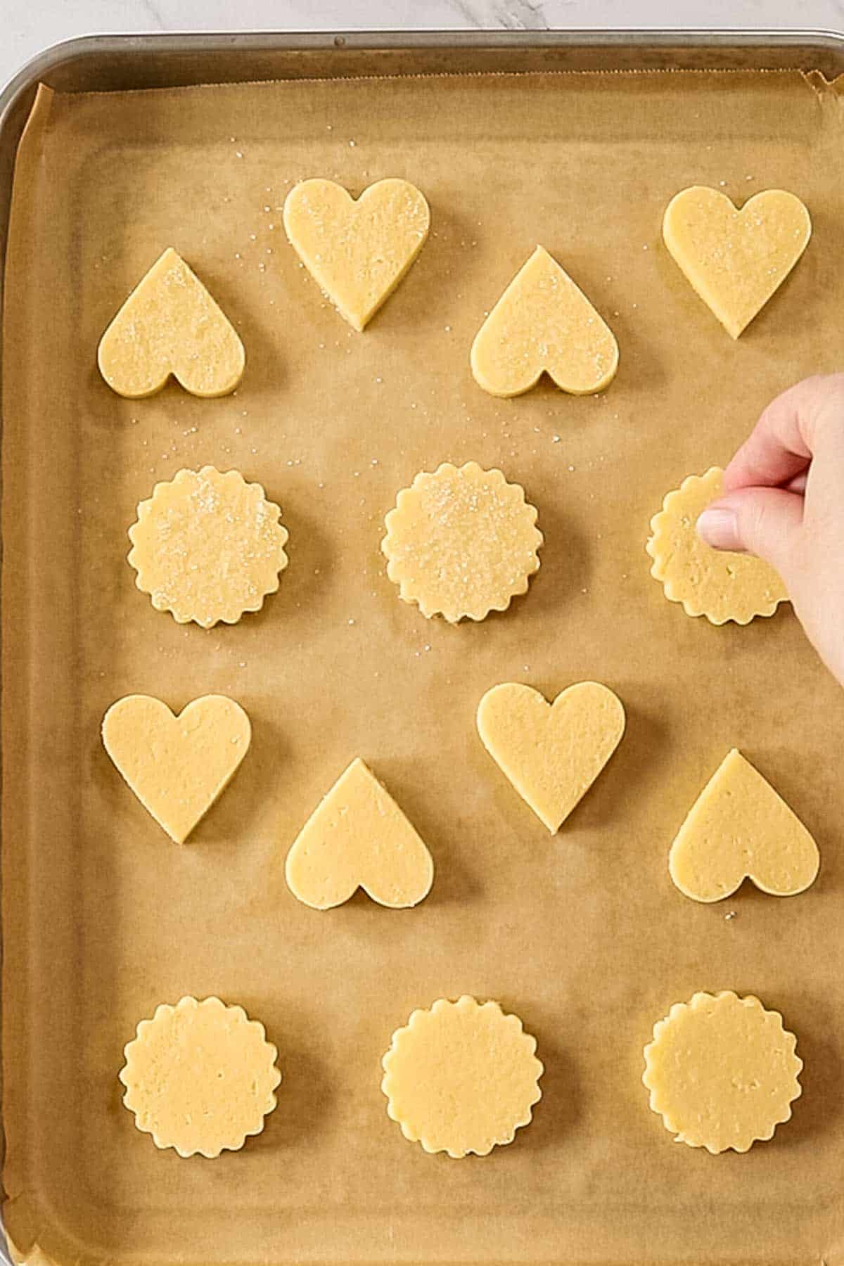 cut outs Christmas butter cookies on a lined baking sheet
