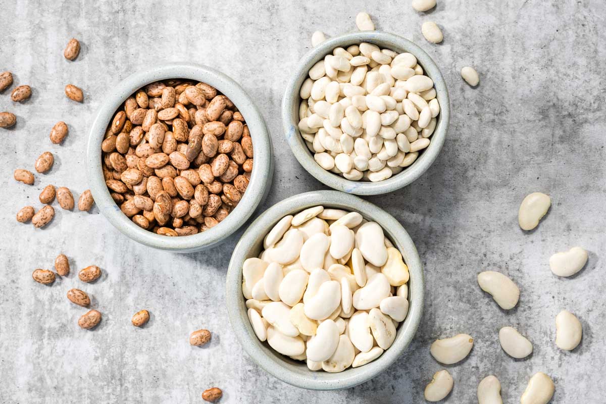 Three bowls of dried beans prepared for cooking in a steam oven.