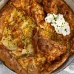 Landscape view of savory Dutch Baby Pancake with cheese, chives, and sour cream.