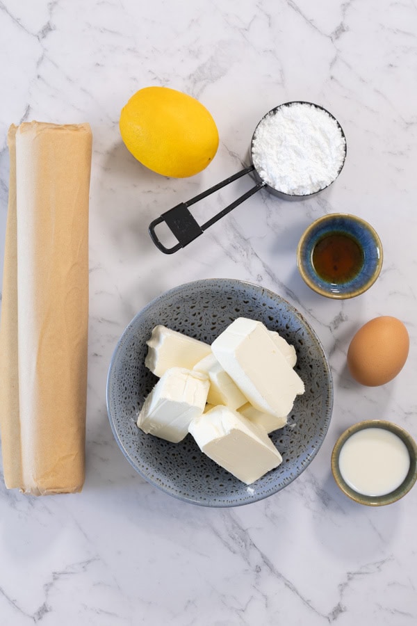 Ingredients for lemon cheesecake danish: cream cheese, lemon, powdered sugar, puff pastry, egg, milk, vanilla extract.