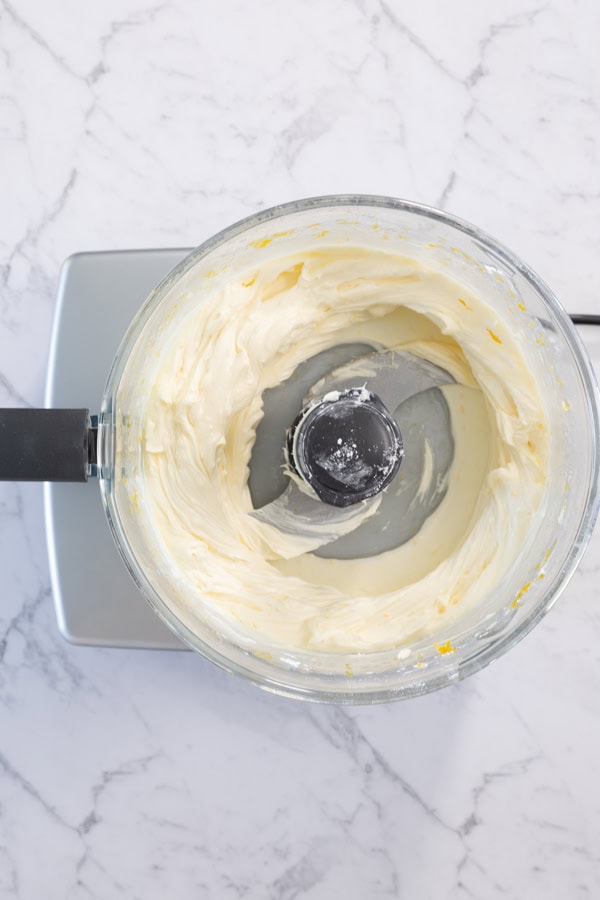 Blended lemon cheesecake filling in a food processor.