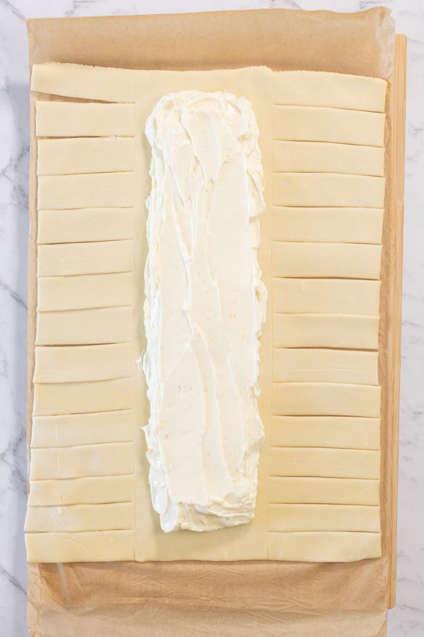 Puff pastry with cheesecake filling spread down the center.