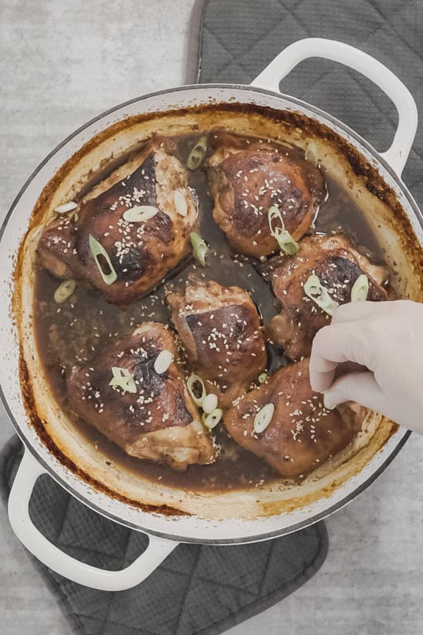 A white round baking dish with freshly roasted miso maple chicken. 