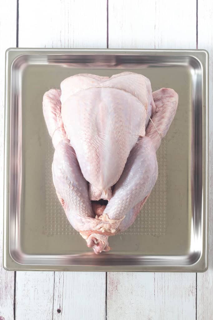 raw whole turkey on in a pan ready to steam