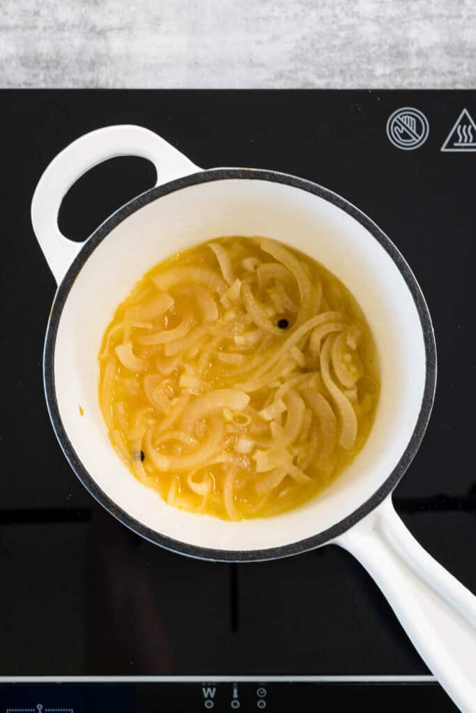 onions, wine and vinegar in a small white saucepan, being reduced down to make acid butter for risotto. 