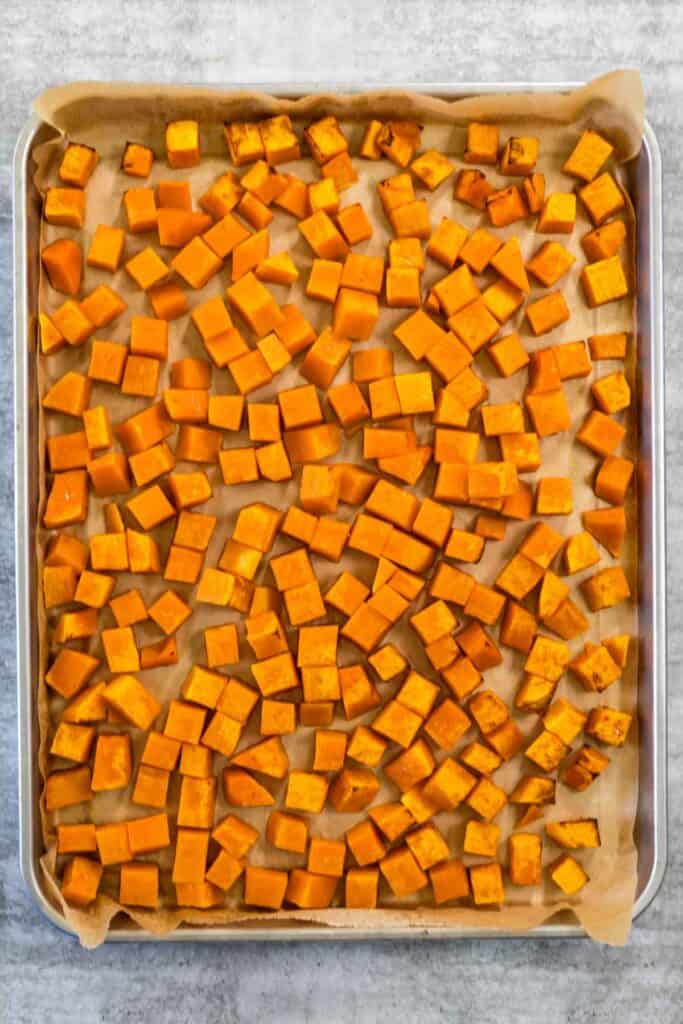 A stainless steel sheet pan with roasted pumpkin, ready to use in risotto. 