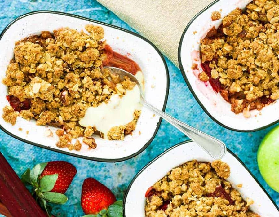 individual enamel dishes filled with red fruit and crumble topping