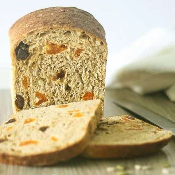 a loaf of bread with two slices cut off the end with apricots and dates inside