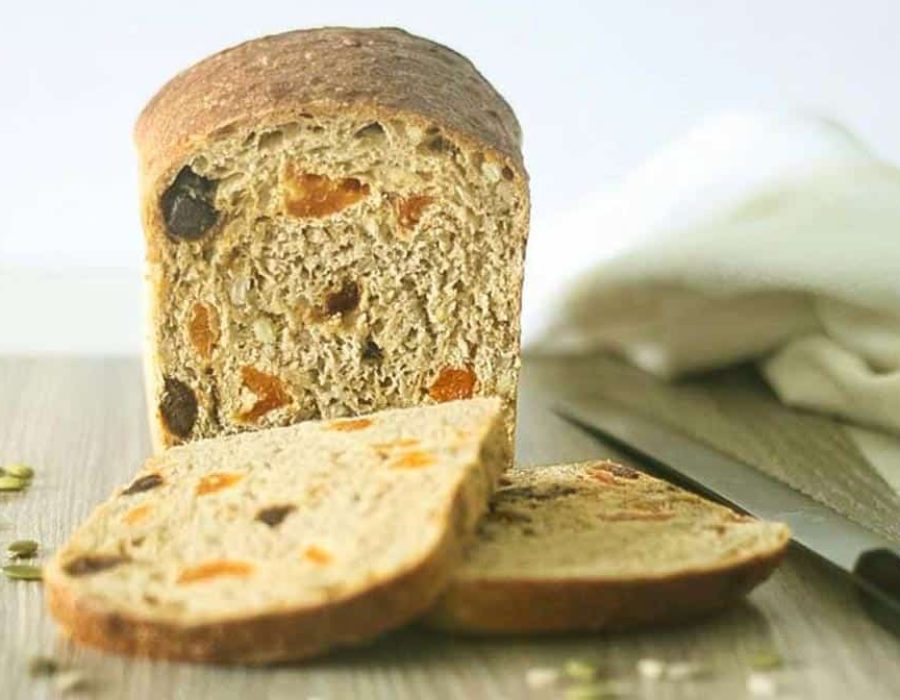 a loaf of bread with two slices cut off the end with apricots and dates inside