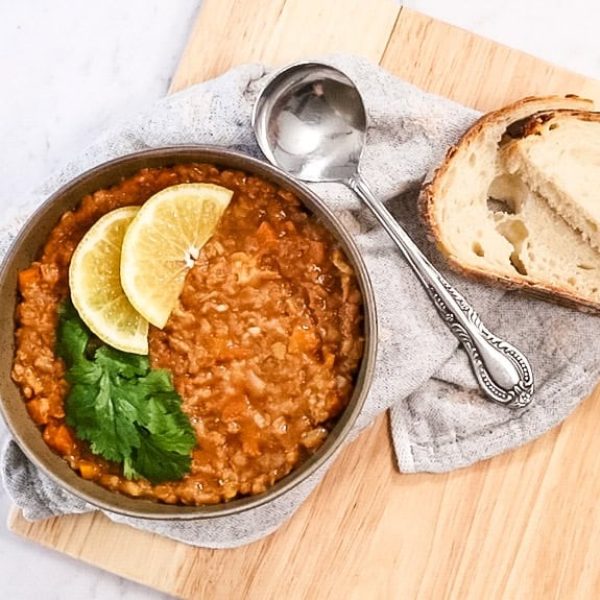 landscape view of arabic lentil soup in a bowl with spoon and slices of bread