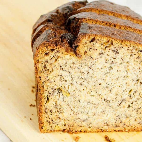 close up image of a slice of banana bread on a wooden board