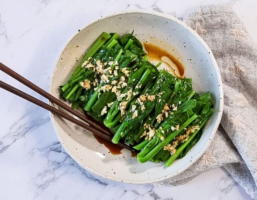 landscape view of chinese steamed vegetables on a plate with a pair of chopstick