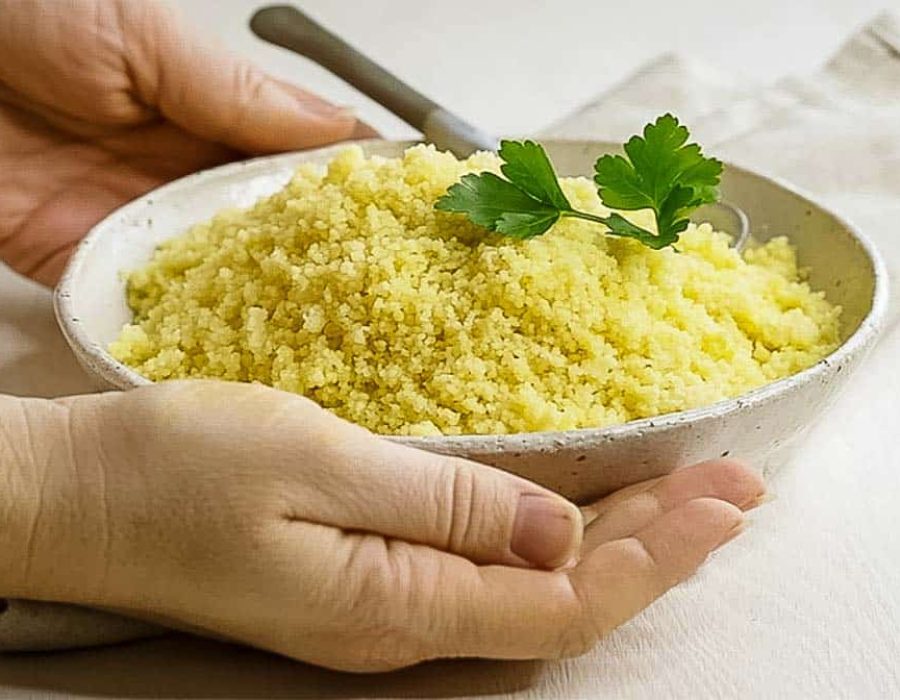 bowl of couscous being presented by two hands
