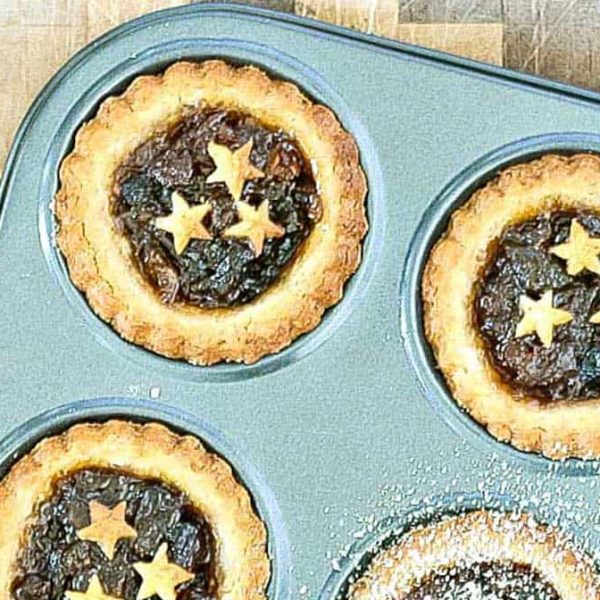 a few fruit mince pies with scalloped pastry and pastry stars garnishing the filling