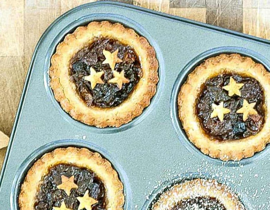 a few fruit mince pies with scalloped pastry and pastry stars garnishing the filling