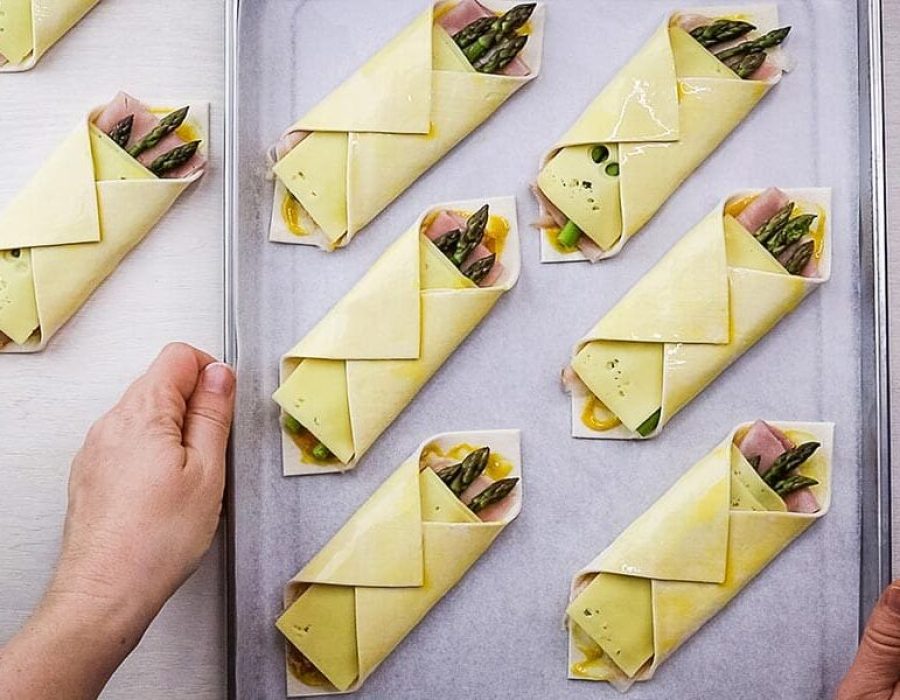 diagonally folded savoury pastries arranged on a tray
