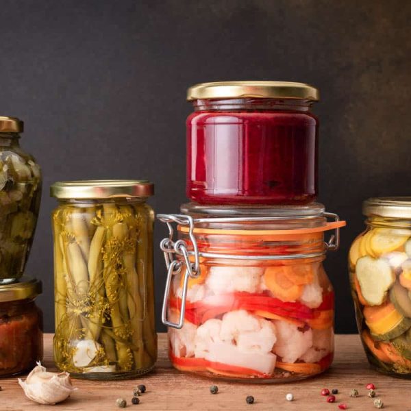 Preserving vegetables for the winter, canned vegetables in jars on a wooden table against a brown wall, pickled or fermented vegetables, copy space