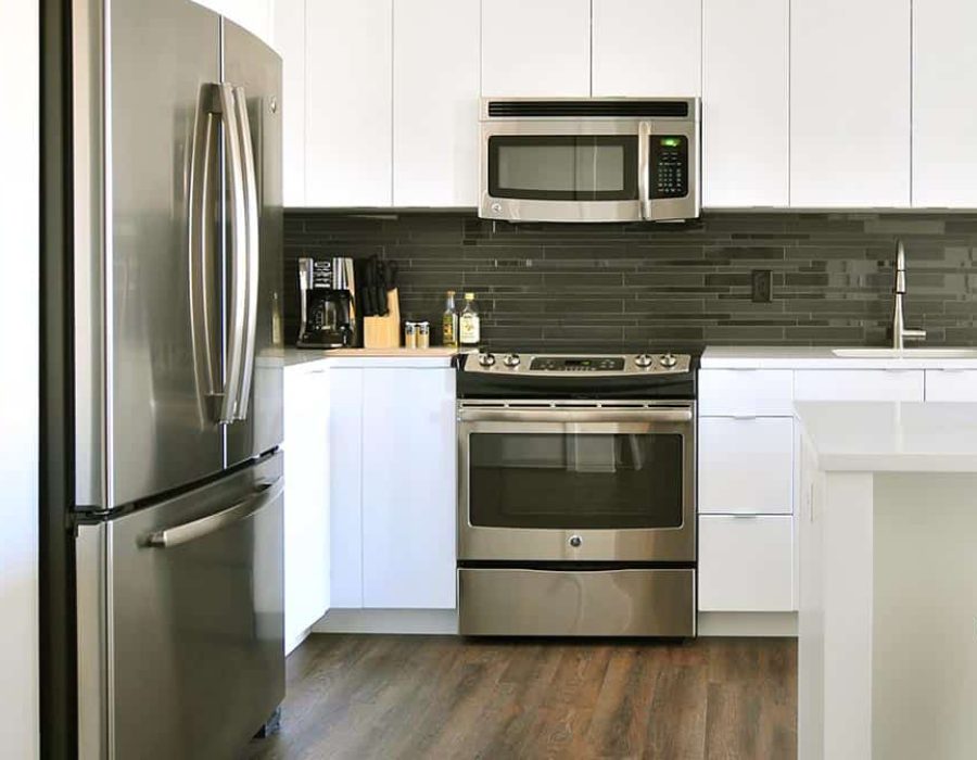 a kitchen with white cabinets and stainless steel appliances