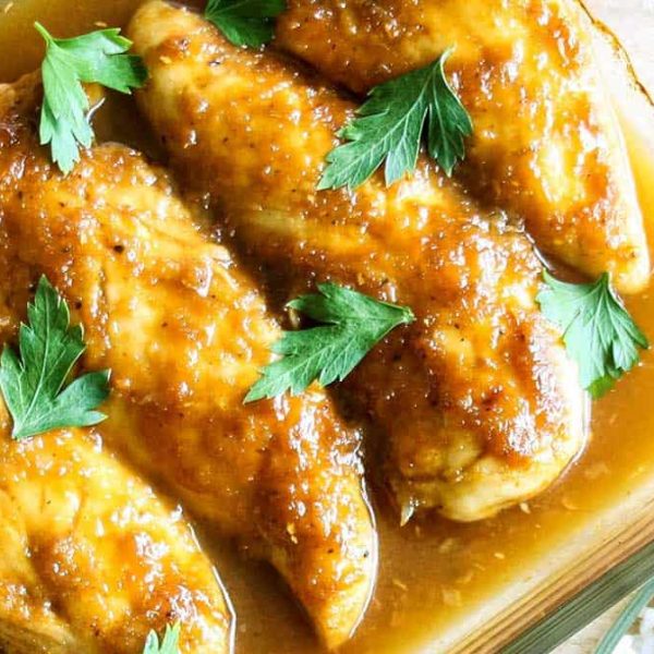 a close up picture of chicken tenderloins in a golden sauce