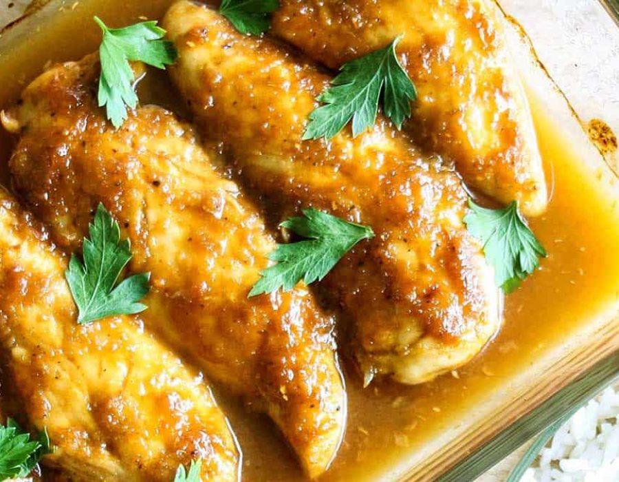 a close up picture of chicken tenderloins in a golden sauce