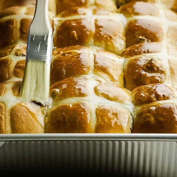 hot cross buns being glazed