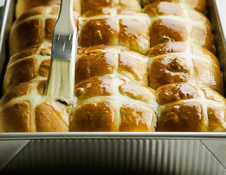 hot cross buns being glazed