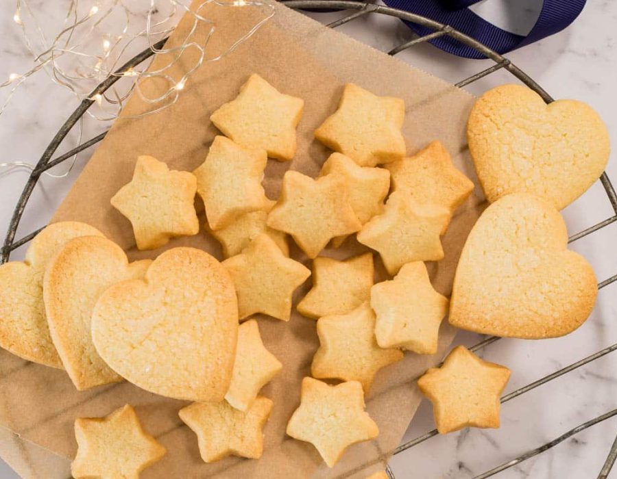 freshly baked, shaped Christmas butter cookies on a lined cooling rack