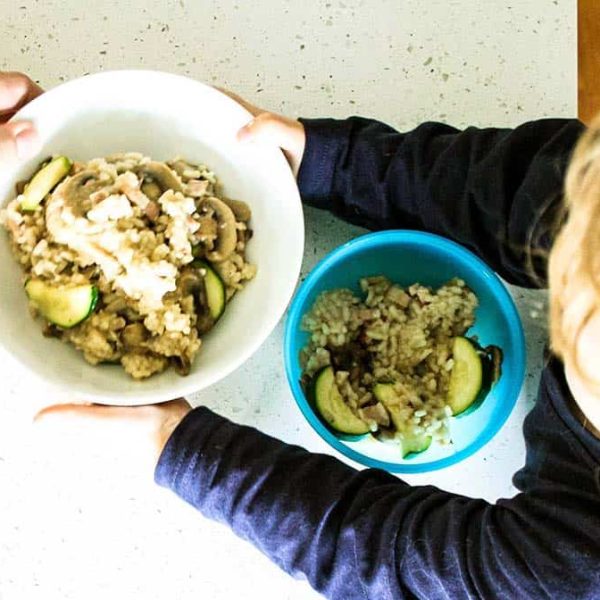 child holding risotto bowl